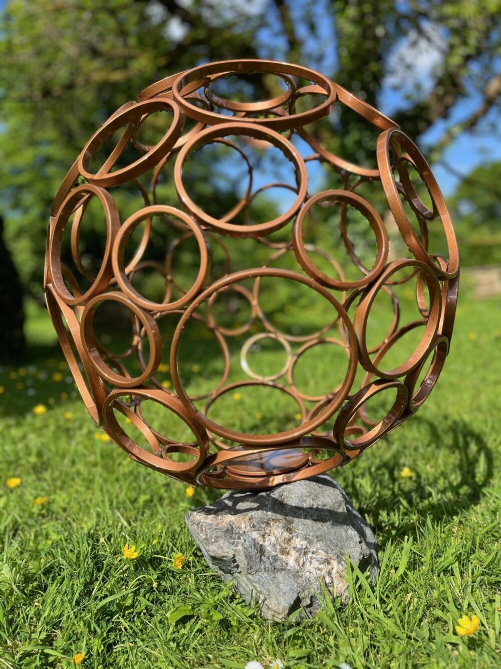 Garden Sculpture Copper Ringed Sphere Artwork mounted in natural stone